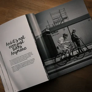 Ein aufgeschlagenes Buch, in dem ein Schwarz-Weiß-Foto von Radfahrern zu sehen ist sowie die Überschrift “And it’s not even just bikes anymore”.