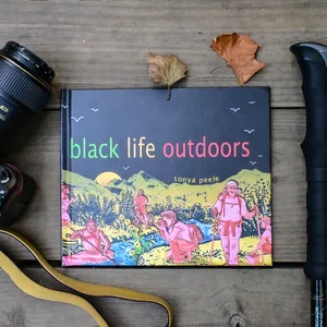 A colorful book or magazine cover titled "black life outdoors" featuring vibrant illustrated flowers and plants against a dark background.