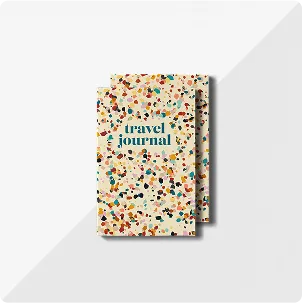 A stack of two travel journals with a colorful, abstract paint splatter design on the front cover