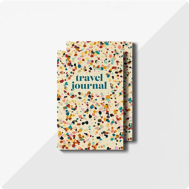 A stack of two travel journals with a colorful, abstract paint splatter design on the front cover