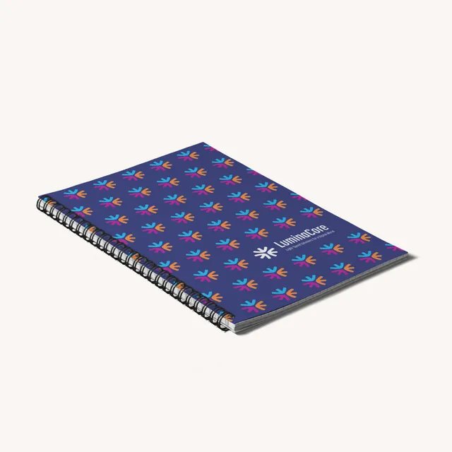 Wire-O-gebundenes Softcover-Notizbuch mit blau gemusterter Covergestaltung und schwarzer Spiralbindung.