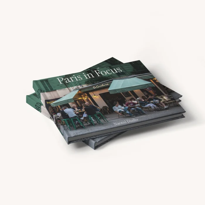 Stack of ImageWrap hardcover photo books titled "Paris in Focus" with an outdoor café cover image.