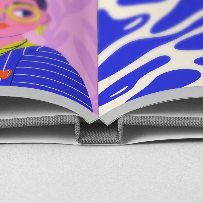 Nahaufnahme der Bindung eines aufgeschlagenen Buches mit Leinenhardcover und Schutzumschlag, in dem auf beiden Seiten farbenfrohe Kinderbuch-Illustrationen zu sehen sind.