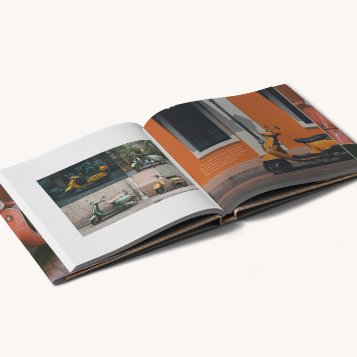 Hardcover linen photo book with dust jacket opened to a two-page spread showing various images of Vespas on Italian streets.