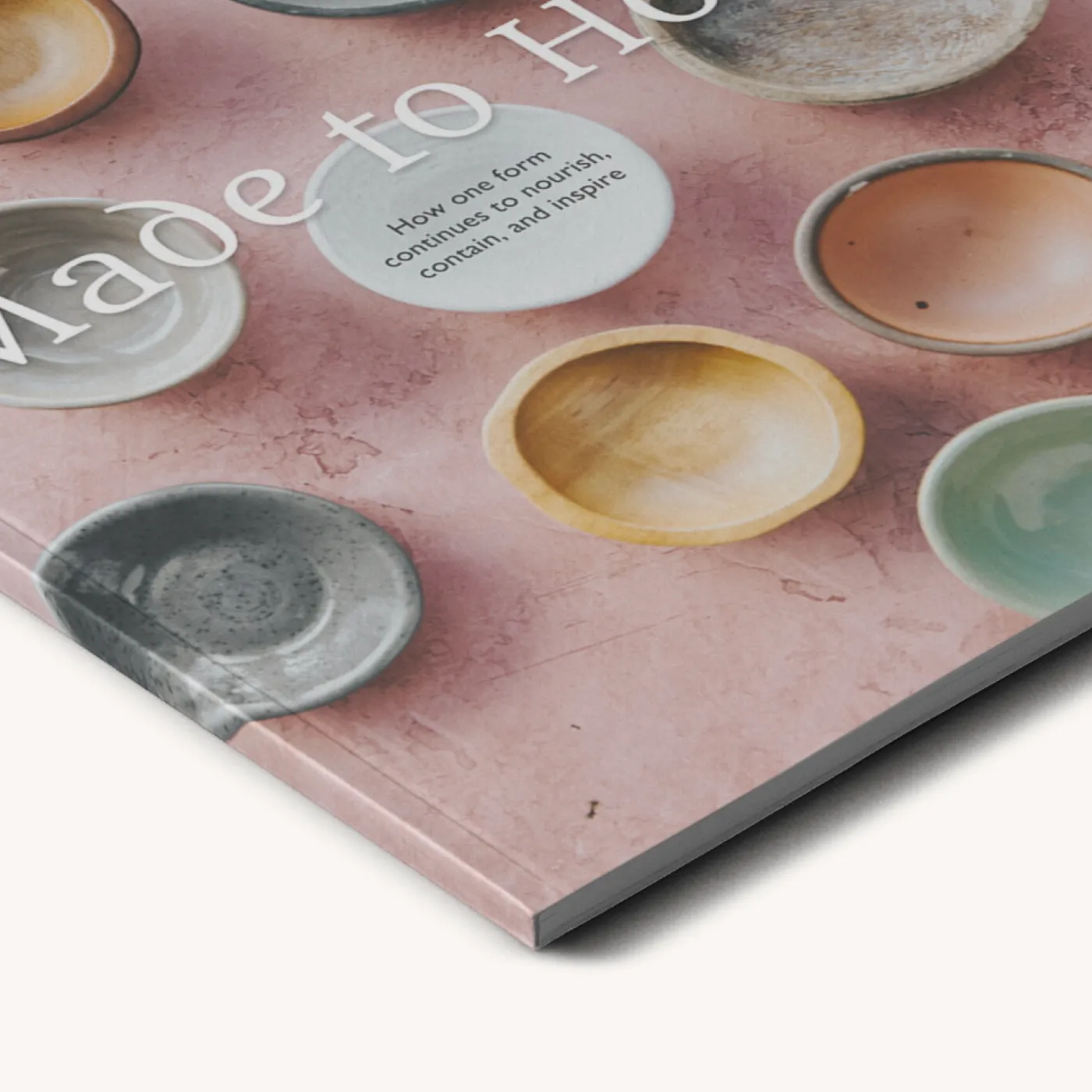 Nahaufnahme eines Magazincovers mit bunten Keramikschalen und Töpferwaren auf rosafarbenem Hintergrund.