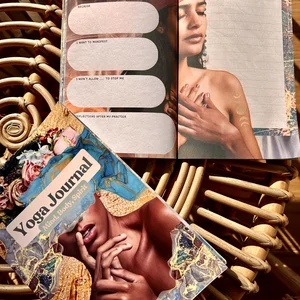 Ein farbenfrohes, aufgeschlagenes Yoga-Tagebuch auf einem Rattantisch, in der eine Tagebuchseite mit einer Meditation für den Tag zu sehen ist.