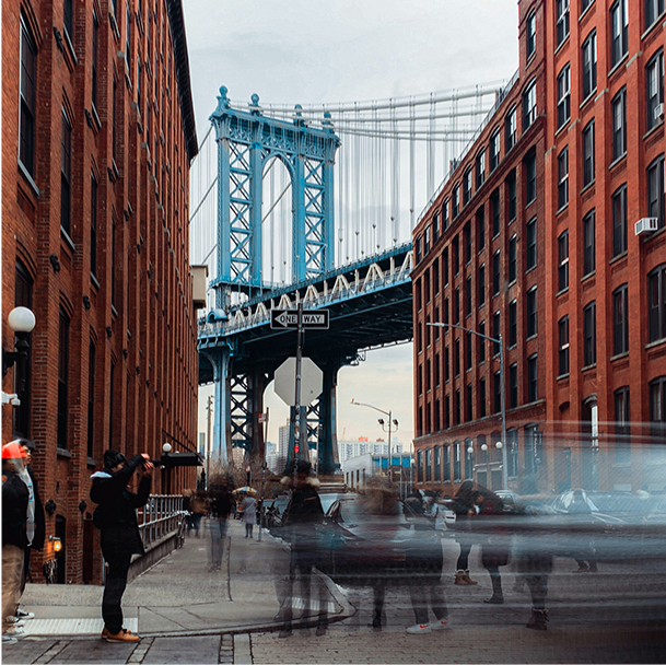 New York City Photowalk (4/22/25) - New York City Iconic Bridge Shot. A vibrant photo of the Manhattan Bridge framed by red brick buildings, capturing NYC's dynamic cityscape.