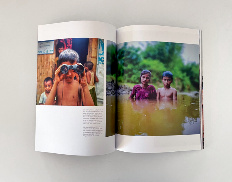 Custom magazine shown open featuring a child looking through binoculars on one page, two children standing waist-deep in a river on the opposite page.